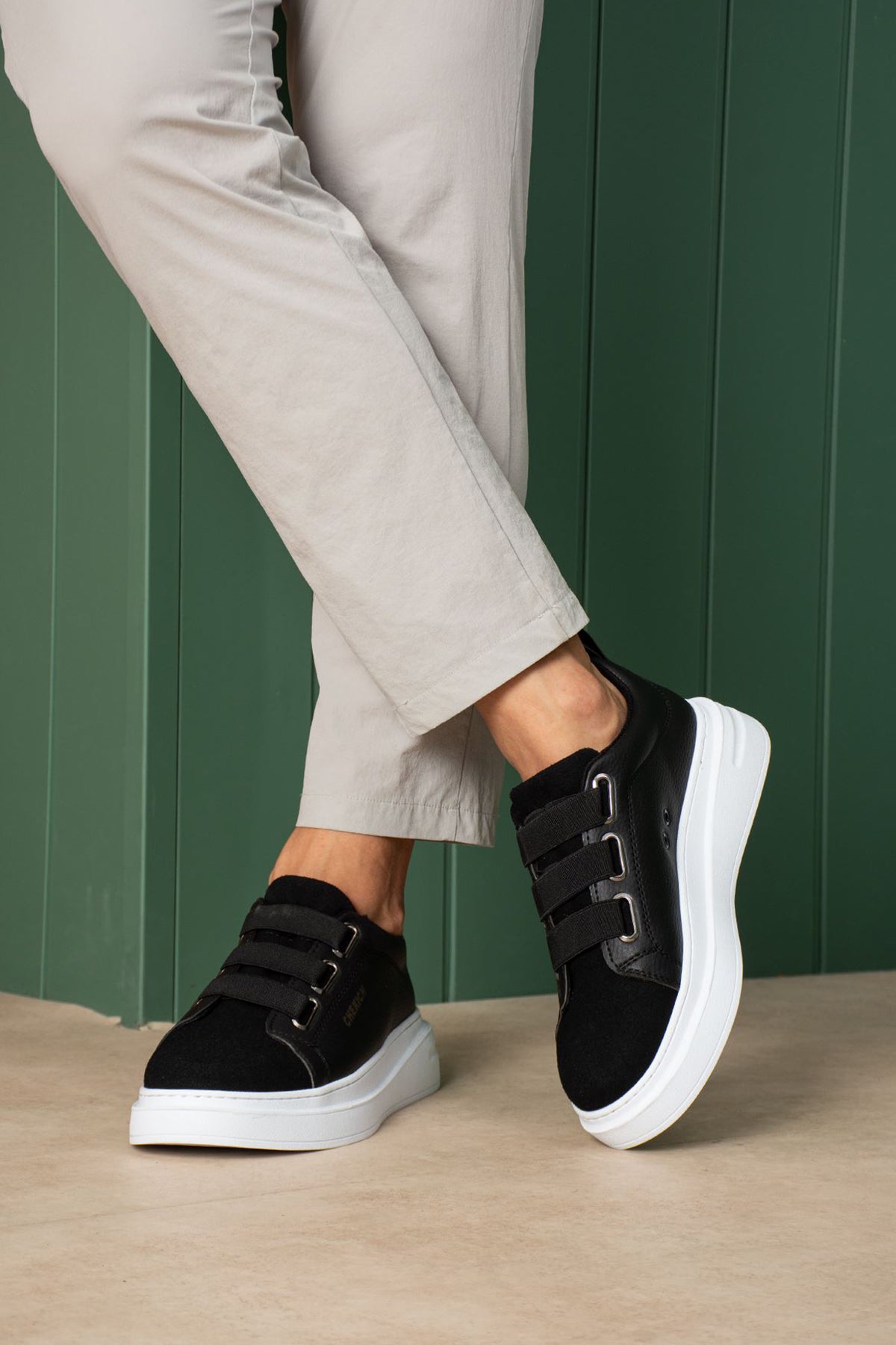 Black low-top sneakers with white soles and strap detail across the tongue area.