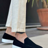 Black suede slip-on loafer with white sole, side view