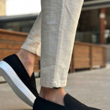 Black suede loafer with white sole, front-side view