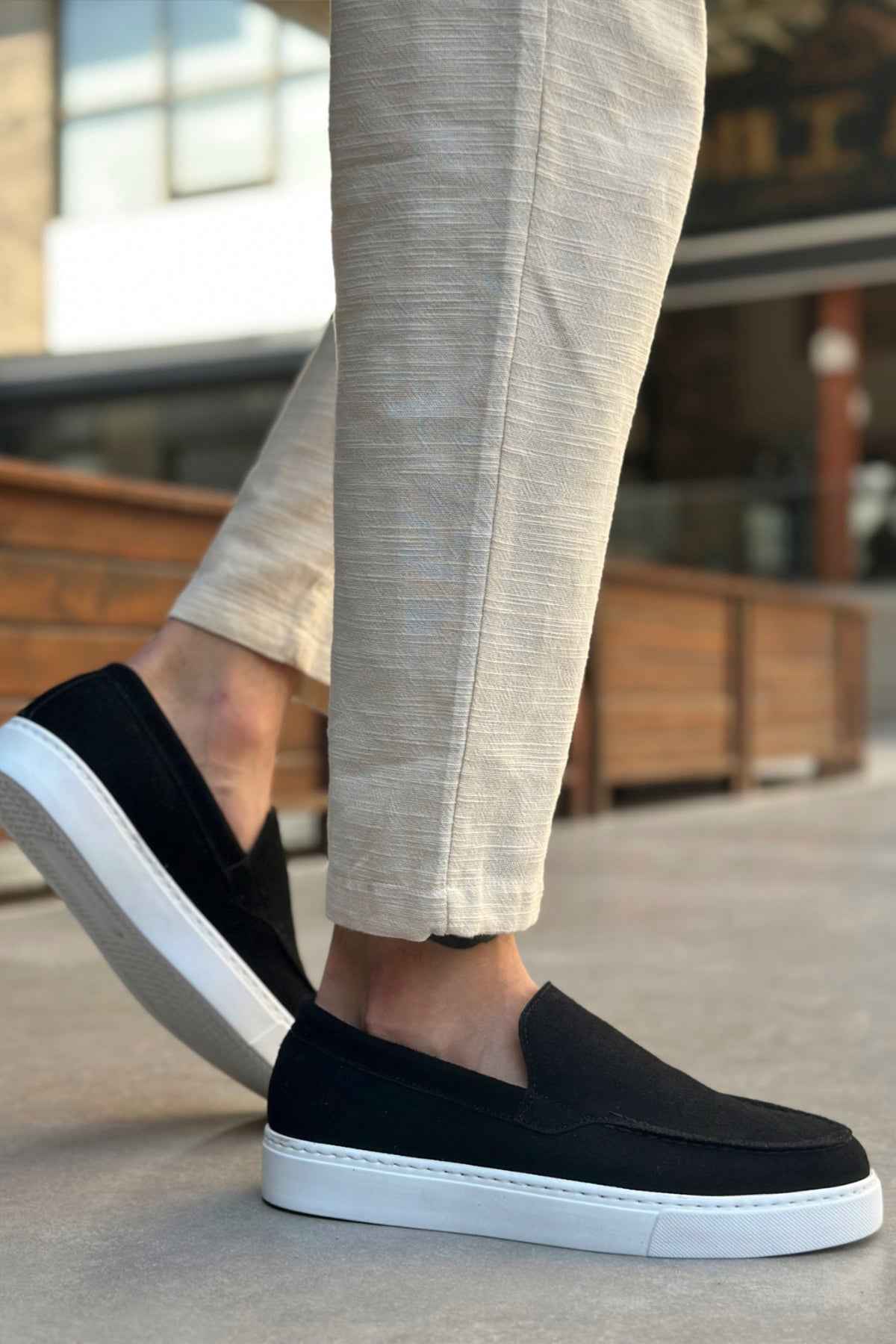 Black suede loafer with white sole, front-side view