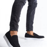 Men's black suede loafers with white sole, low-top slip-on, worn with jeans