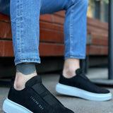 Men's black suede slip-on sneakers with white rubber sole, side logo detail