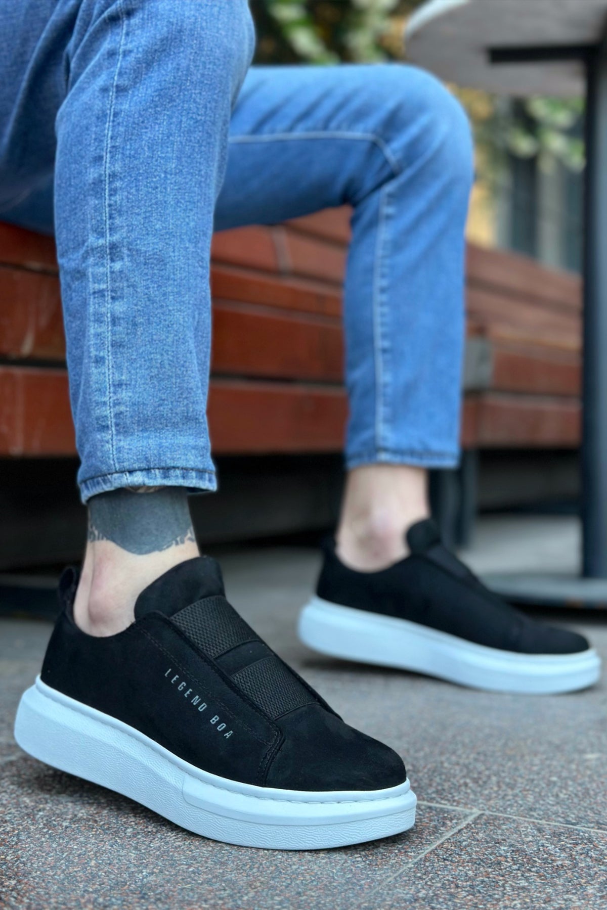 Men's black suede slip-on sneakers with white rubber sole, side logo detail