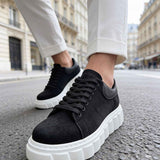 Black suede sneakers with laces, white sole edge and chunky tread