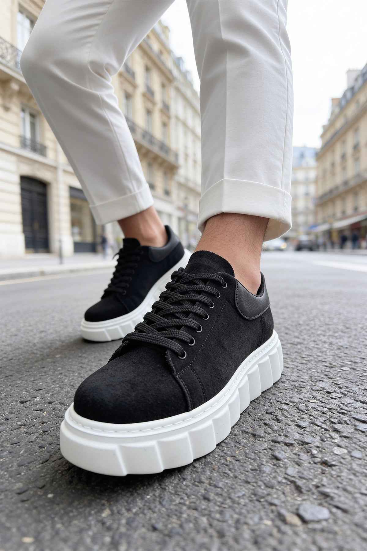 Black suede sneakers with laces, white sole edge and chunky tread