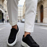 Black suede sneakers, side view with black laces and white textured sole