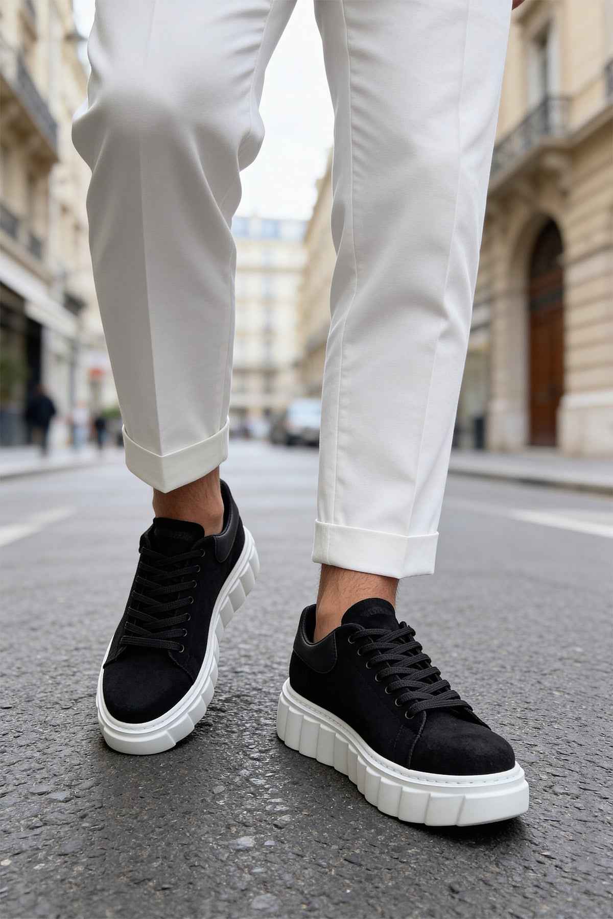 Black suede sneakers, side view with black laces and white textured sole