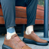 Men's brown slip-on sneakers with dark outsole and stitched strap