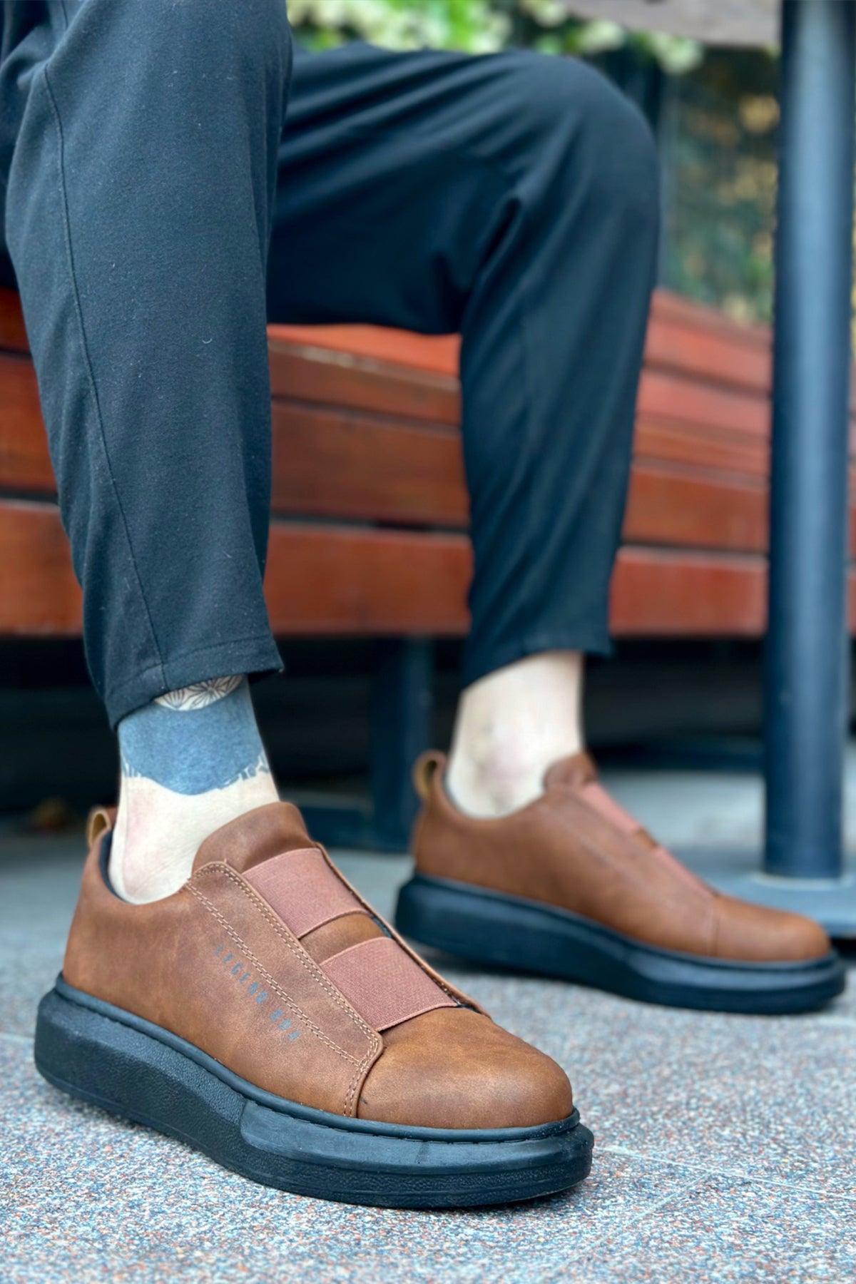 Men's brown slip-on sneakers with dark outsole and stitched strap