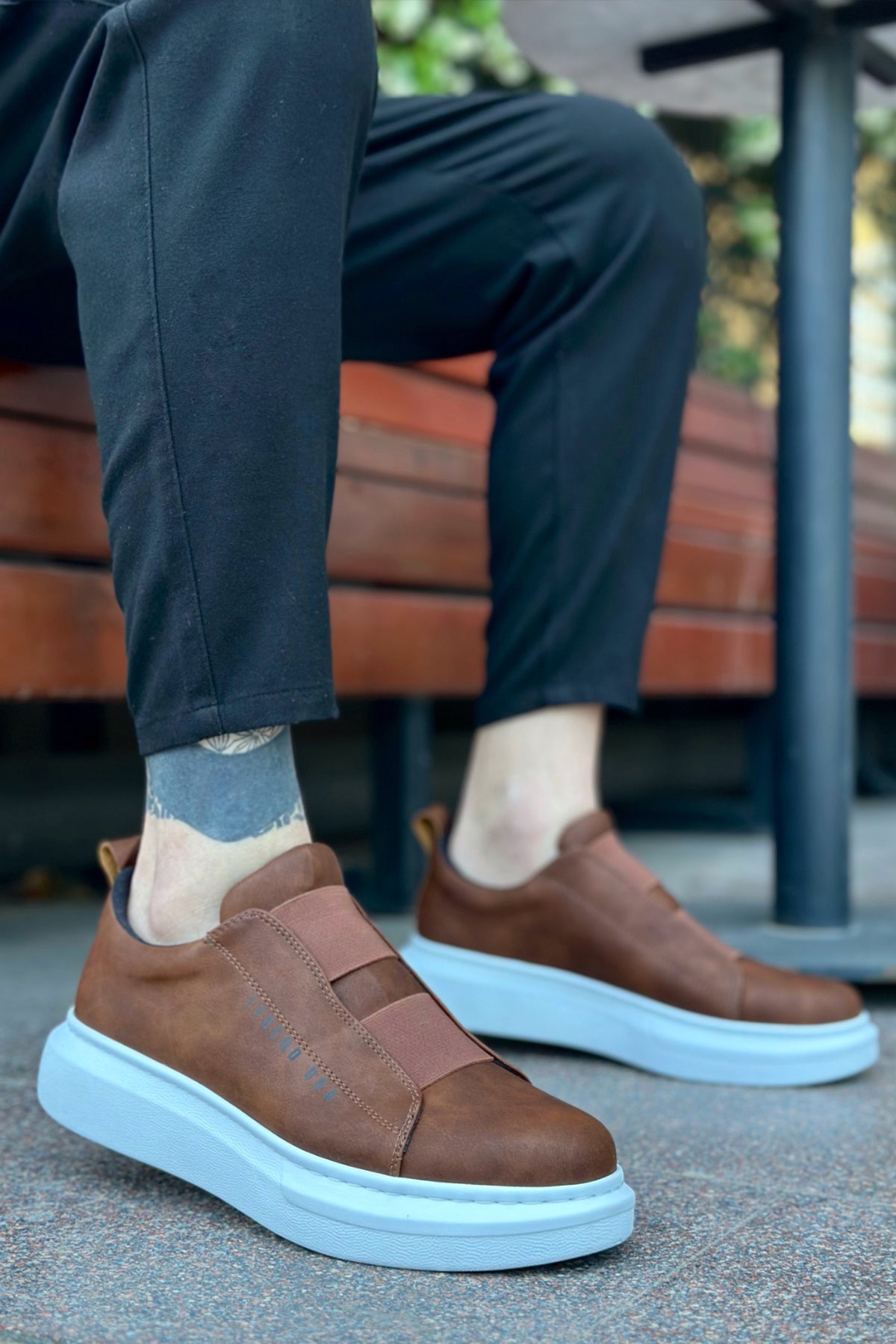 Brown slip-on casual sneakers with light blue sole and stitched detailing