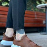 Brown slip-on sneakers with light blue rubber sole and stitched upper