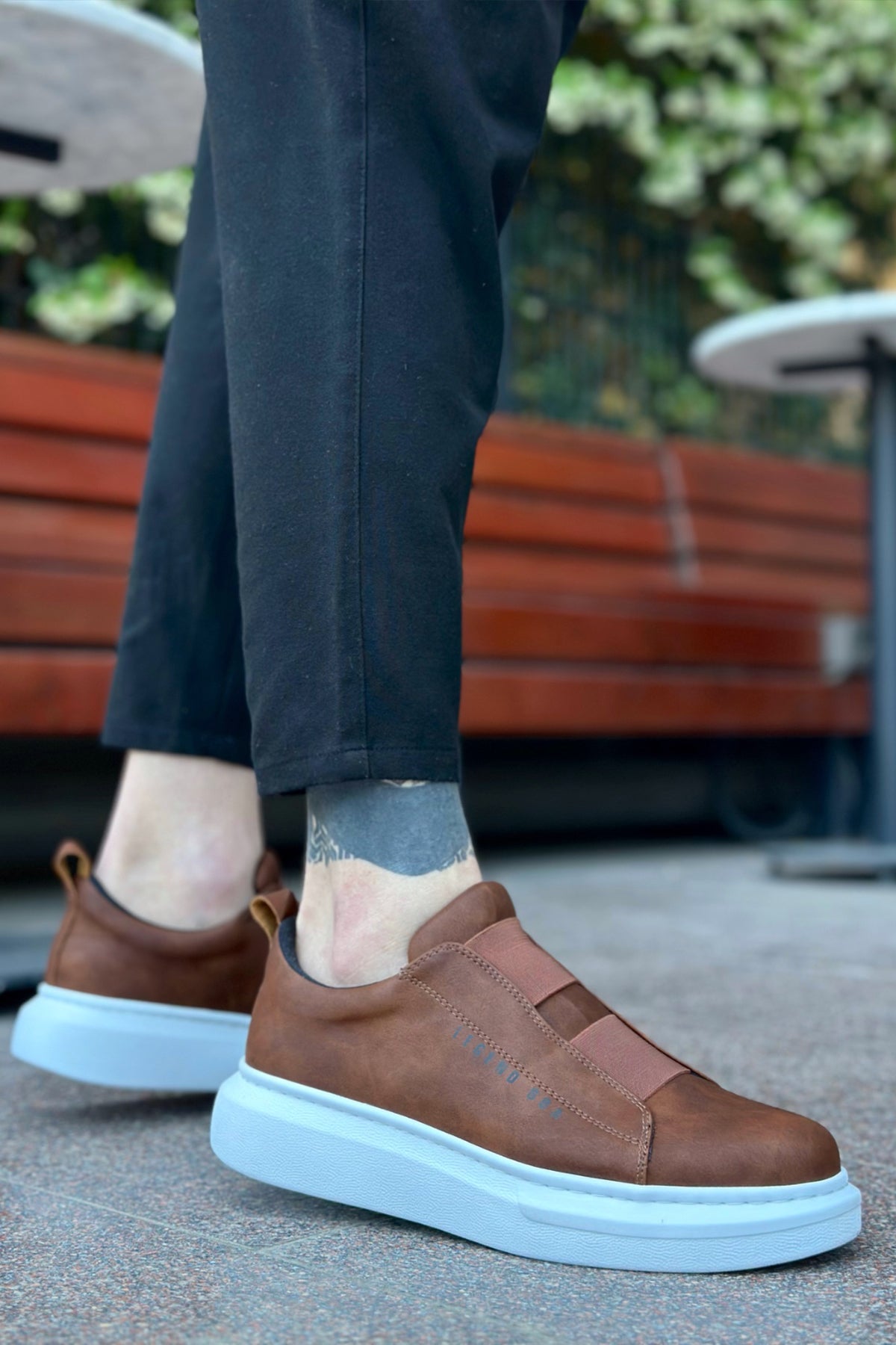 Brown slip-on sneakers with light blue rubber sole and stitched upper