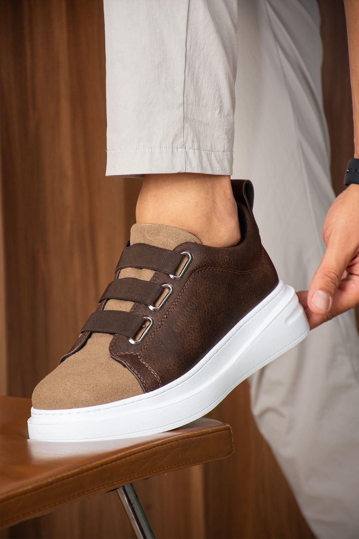 Brown casual sneakers with buckle strap and white midsole, side view