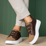 Brown low-top sneakers with adjustable straps and thick white sole, angled view