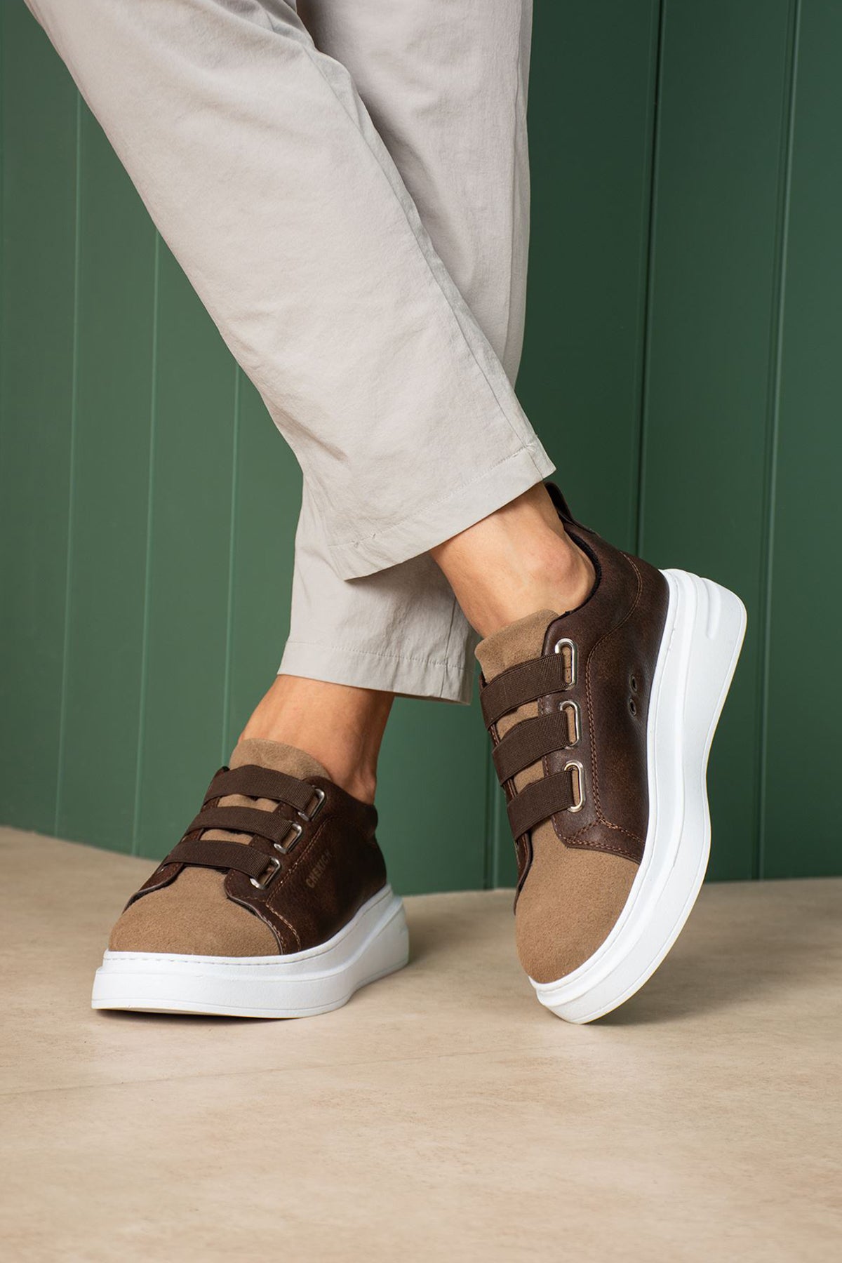Brown low-top sneakers with adjustable straps and thick white sole, angled view