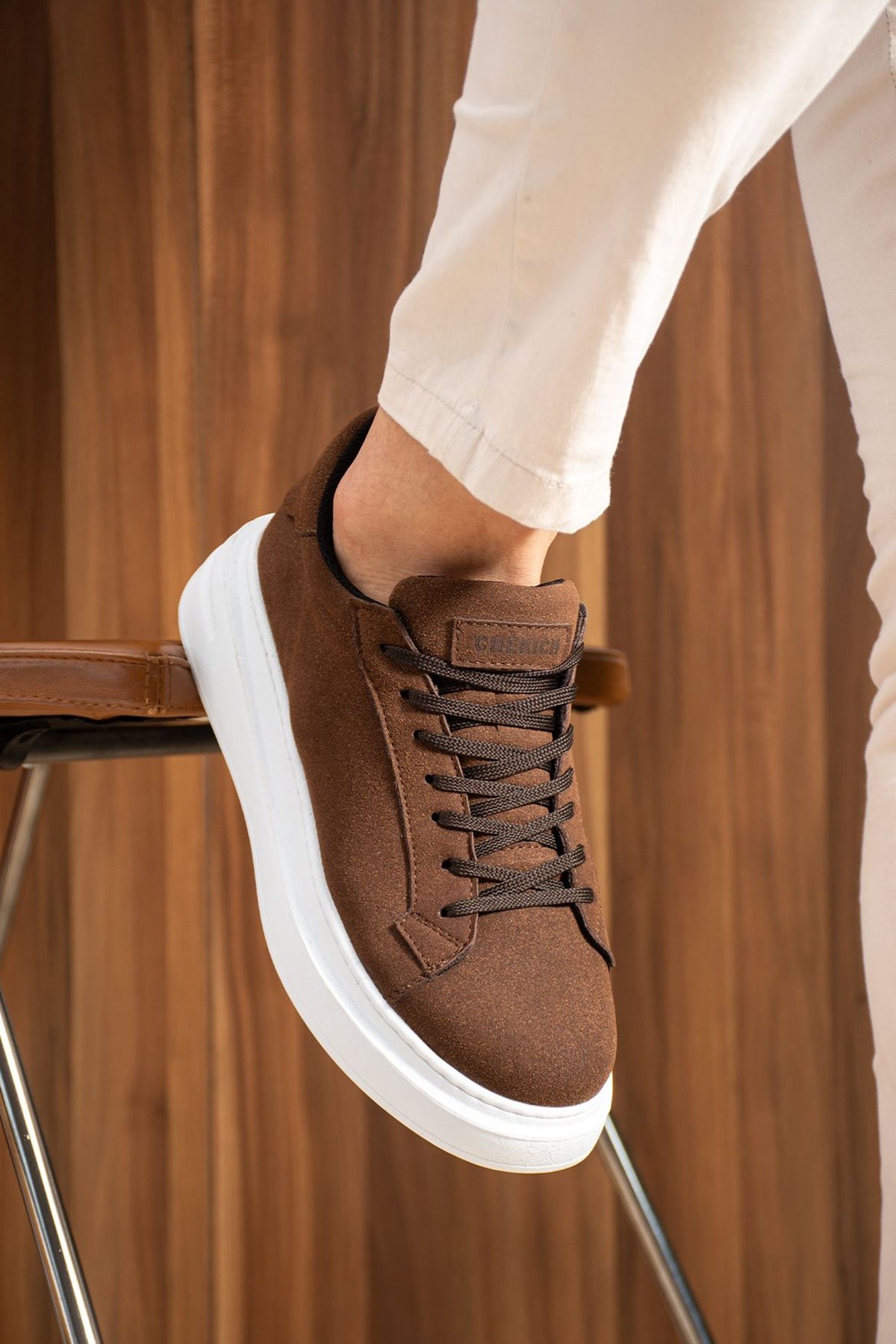 Men's brown suede sneakers with black laces and white rubber sole, side view