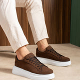 Men's brown suede sneakers on white sole, lace-up front and side angle