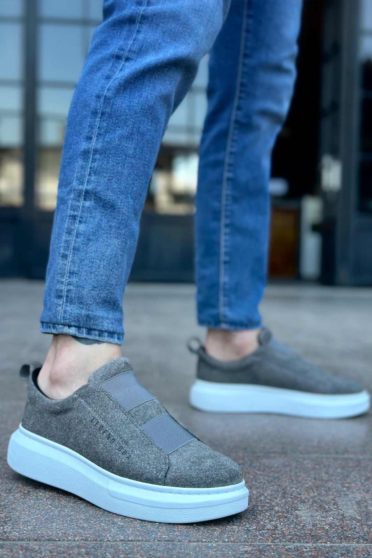 Gray suede slip-on sneakers with light blue accent sole edge