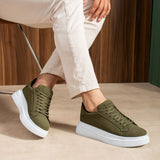 Men's olive suede low-top sneakers, lace-up, white soles, close side step pose
