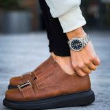 Men’s casual tan sneakers with double buckle straps, black sole, worn with dark pants