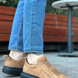 Tan suede slip-on sneakers with black sole, heel and side angle