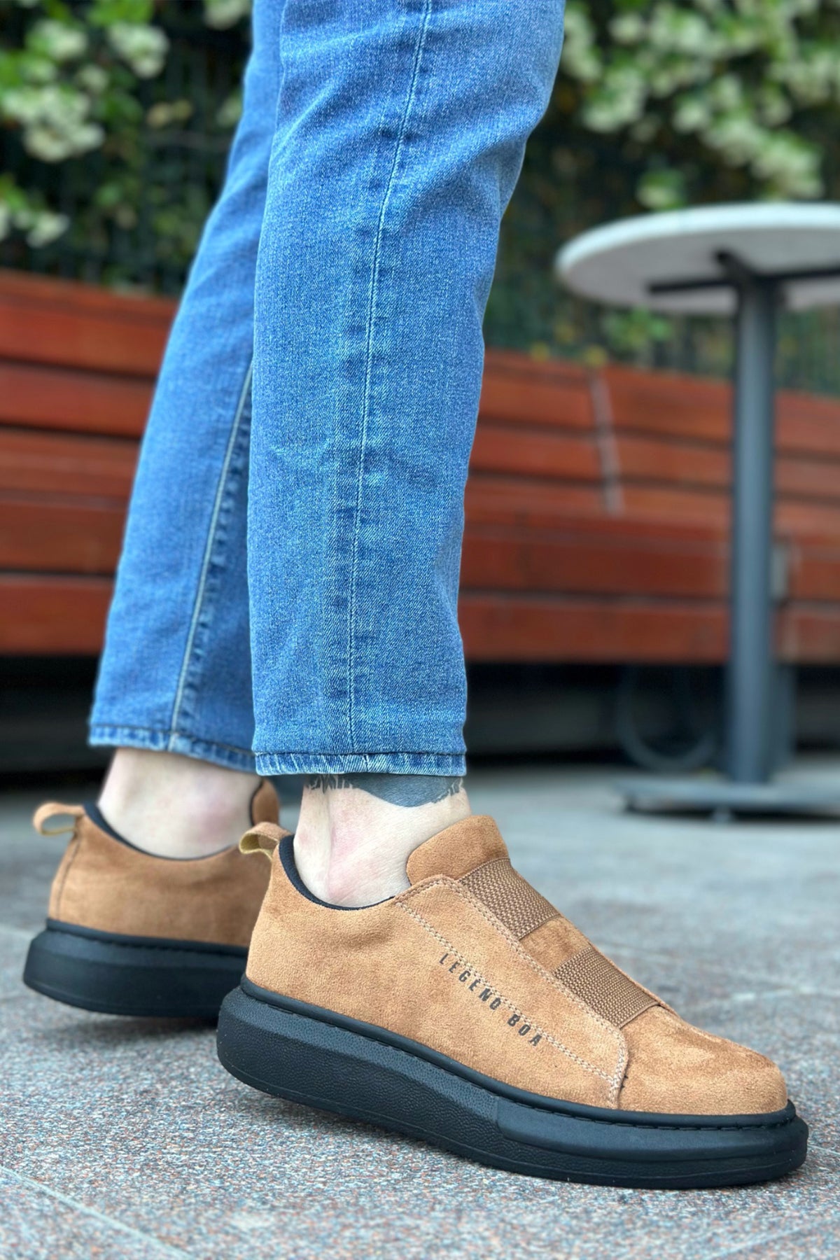 Tan suede slip-on sneakers with black sole, heel and side angle