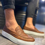 Men's tan suede loafers with slip-on strap and white rubber sole, side view