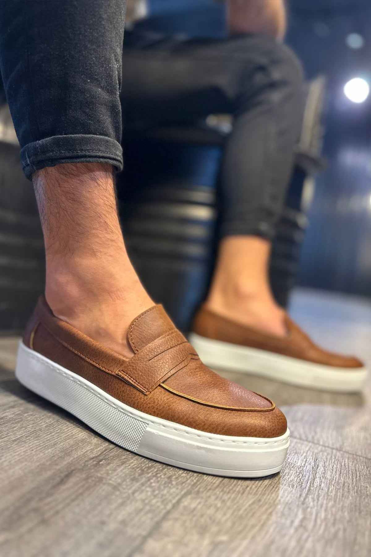 Men's tan suede loafers with slip-on strap and white rubber sole, side view