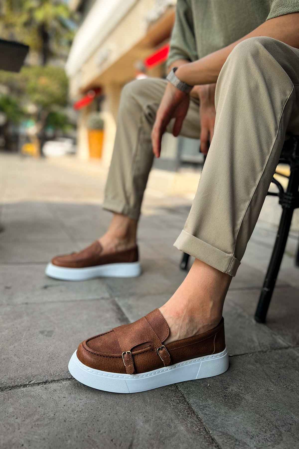 Men's tan casual loafers with buckle strap and white rubber sole