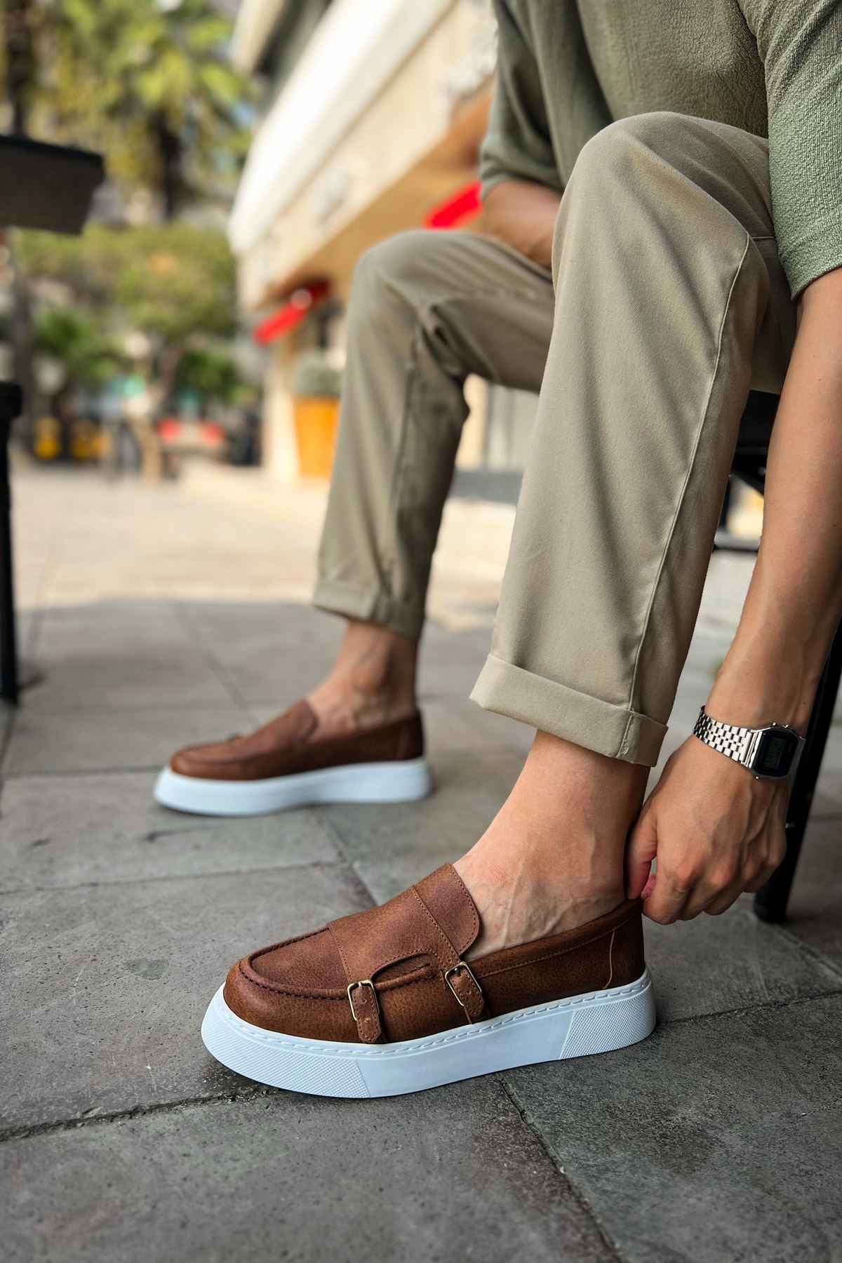 Men's tan loafers, side view, buckle strap with white rubber sole