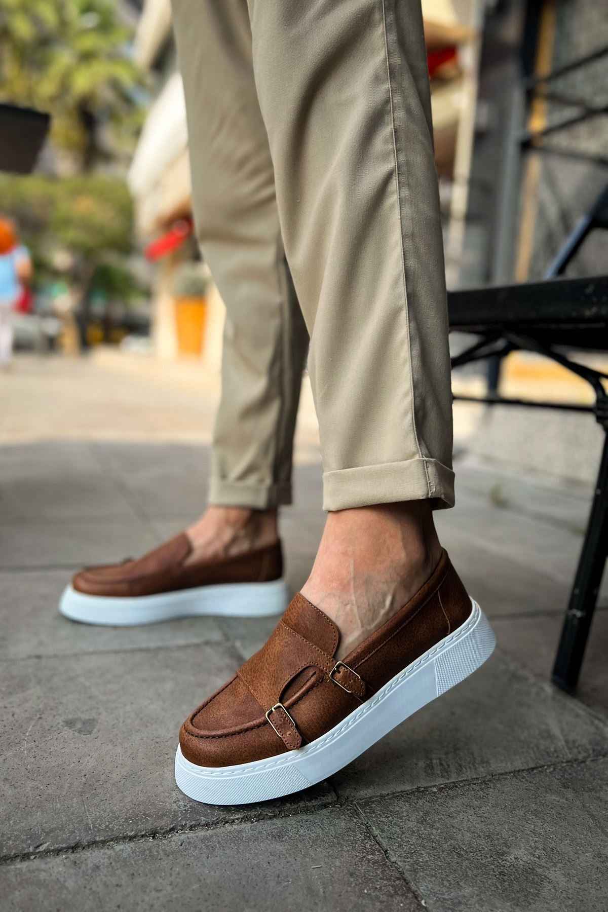Men's tan casual loafers with buckle strap, front angle, white sole