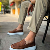 Brown slip-on loafers with white rubber sole, side view.