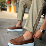 Brown slip-on loafers with white rubber sole, detailed vamp seam.