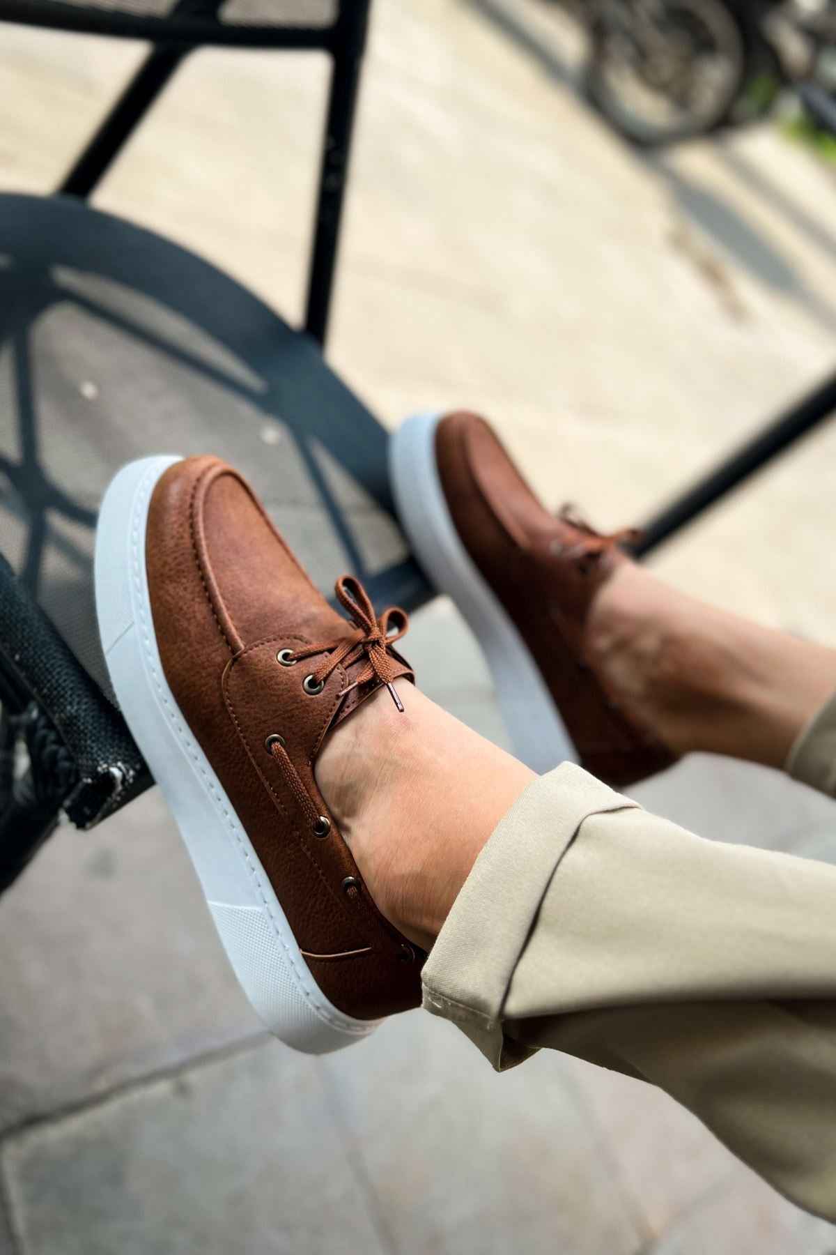 Tan lace-up casual shoe with brown laces and white platform sole edge