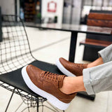 Tan low-top lace-up sneakers with white sole, side stitching texture