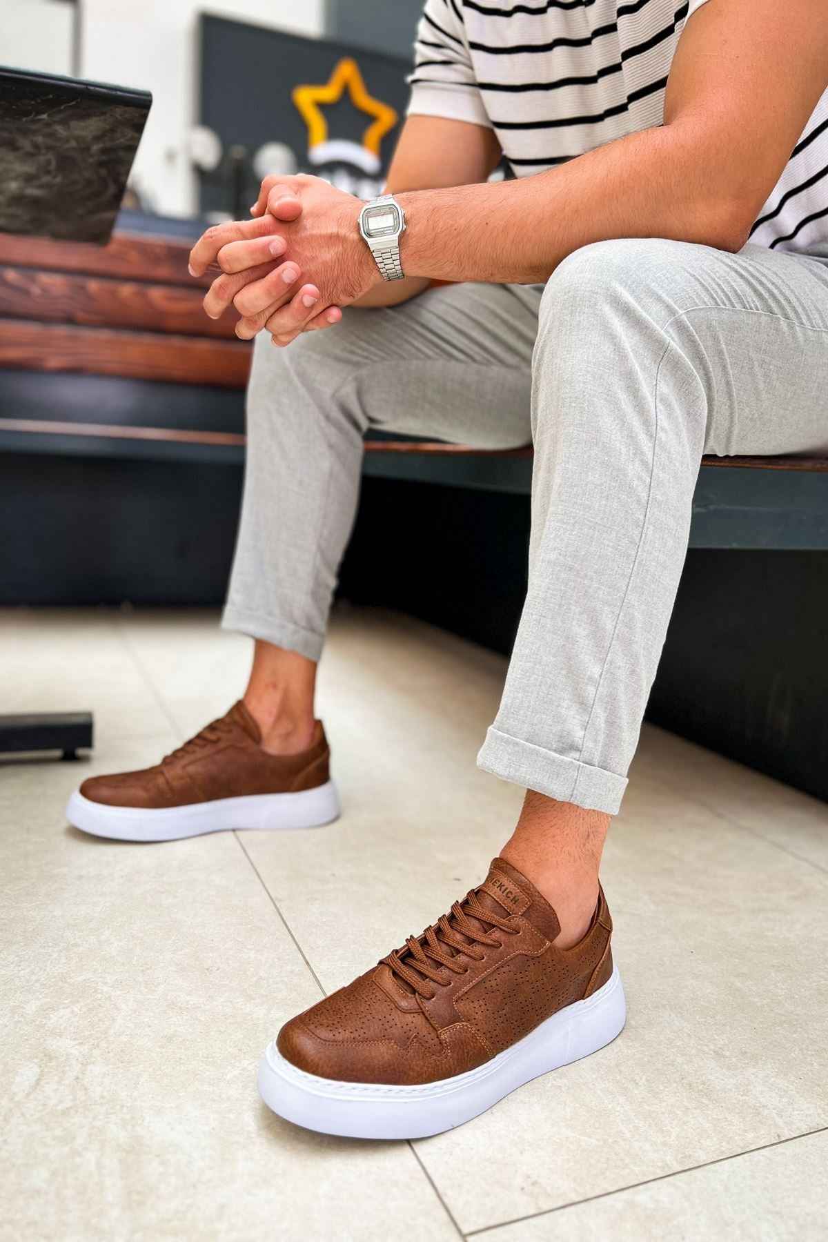 Tan lace-up sneakers with white soles and rounded toe, low-top profile