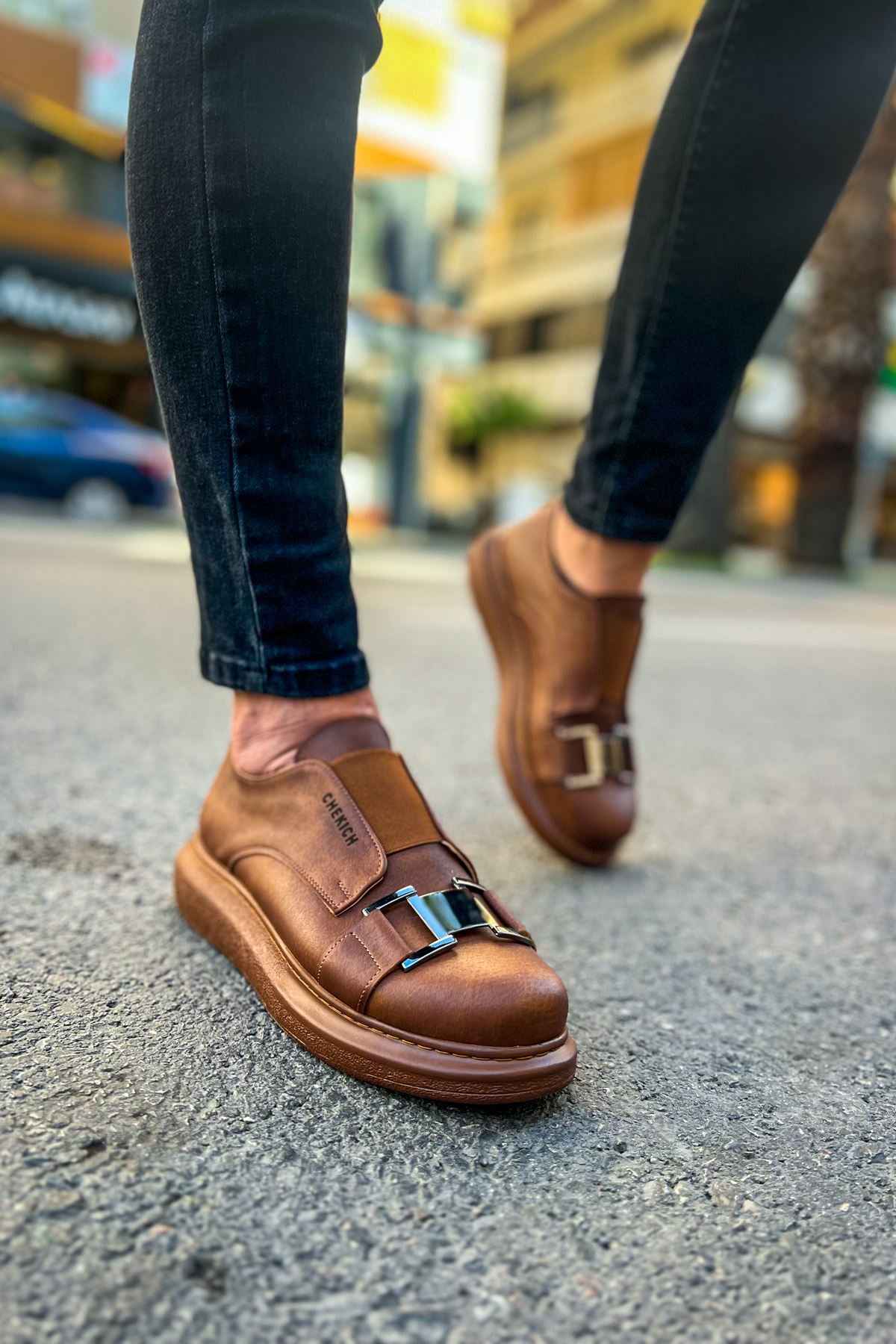 Tan casual sneakers, toe and vamp view, buckled strap across the upper