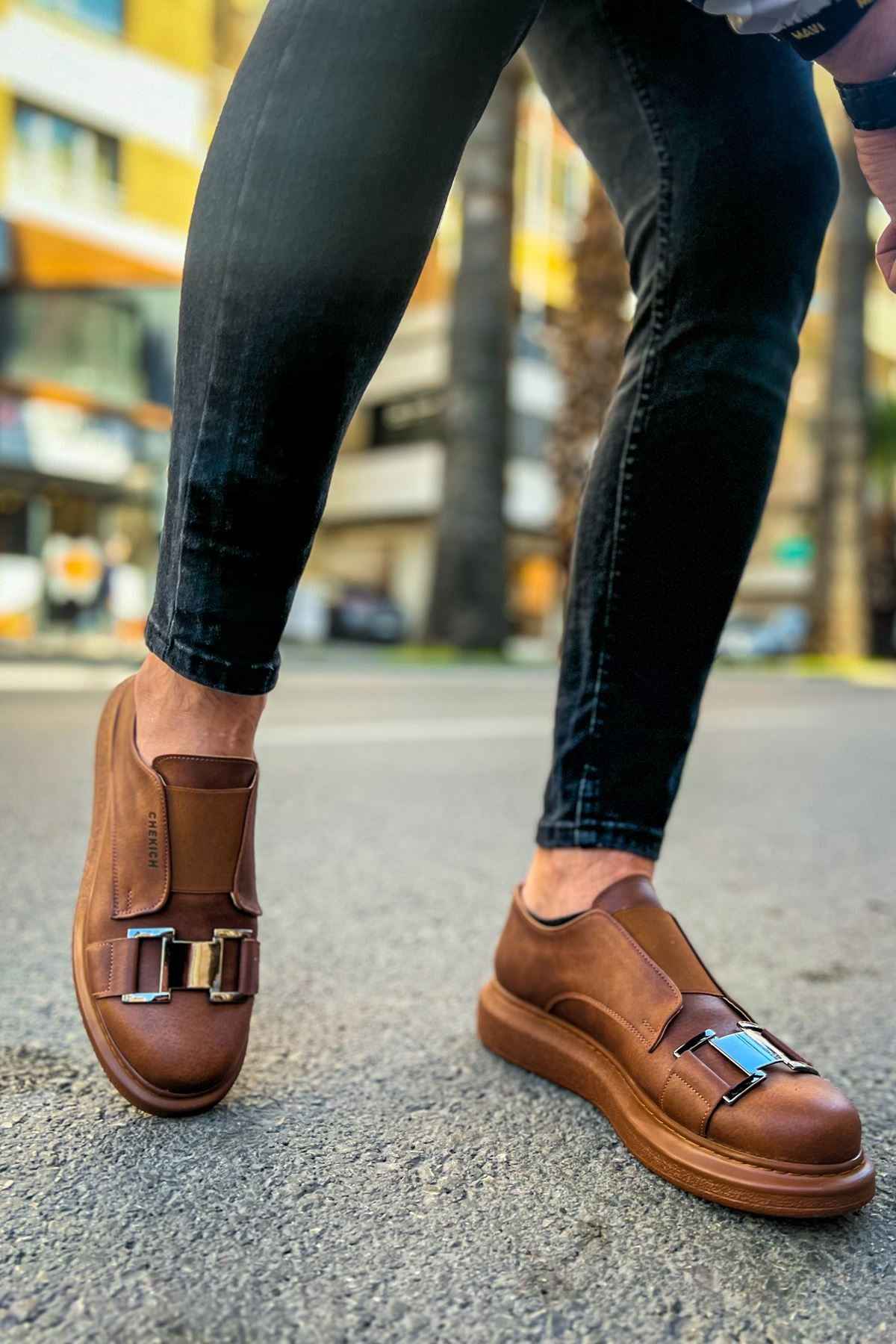 Tan casual sneakers on feet, back and side view, buckle strap detail