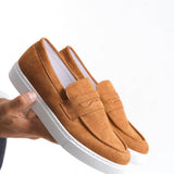 Men's tan suede slip-on loafers with suede upper and white sole, front close-up