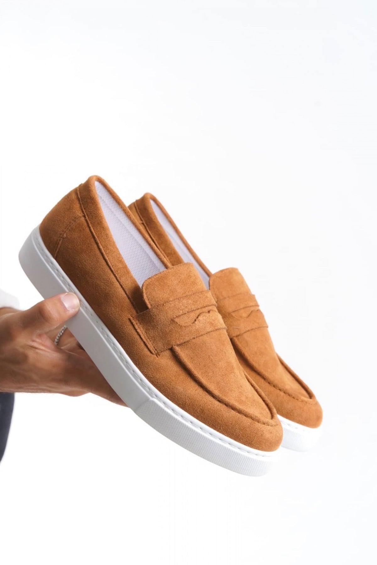 Men's tan suede slip-on loafers with suede upper and white sole, front close-up