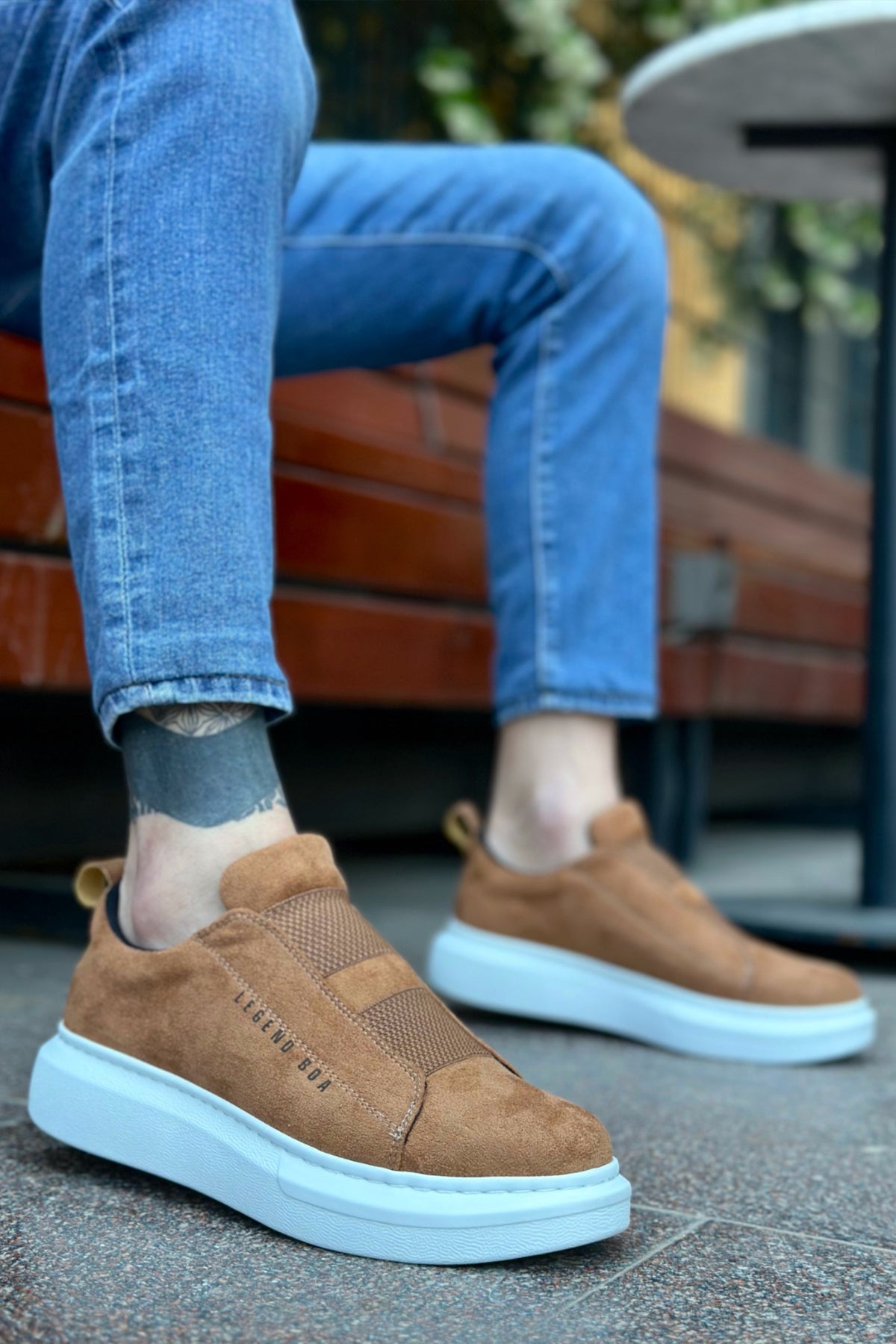 Men's tan suede slip-on sneakers with light blue rubber sole, front view