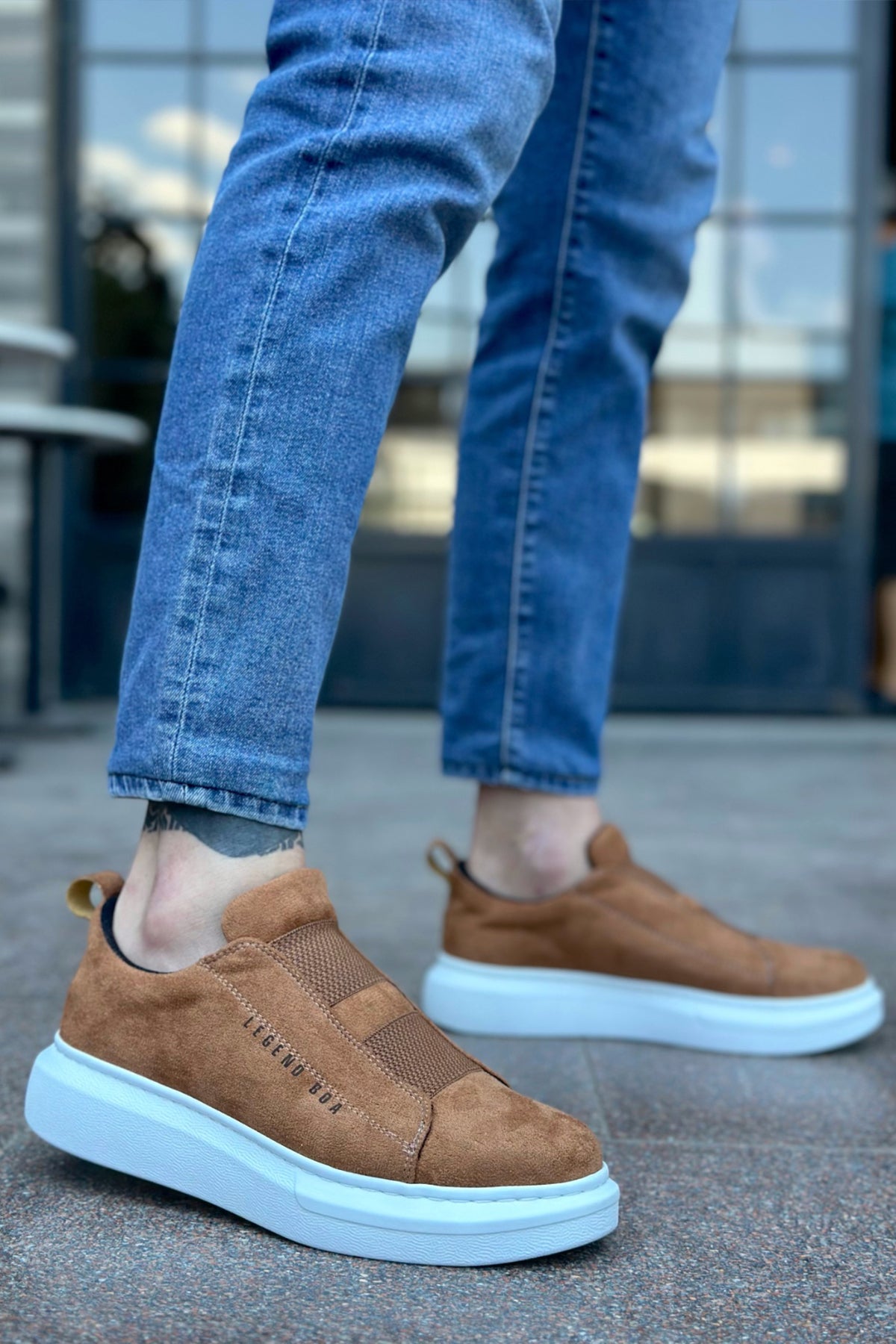 Men's tan suede slip-on sneakers with light blue rubber sole, side profile