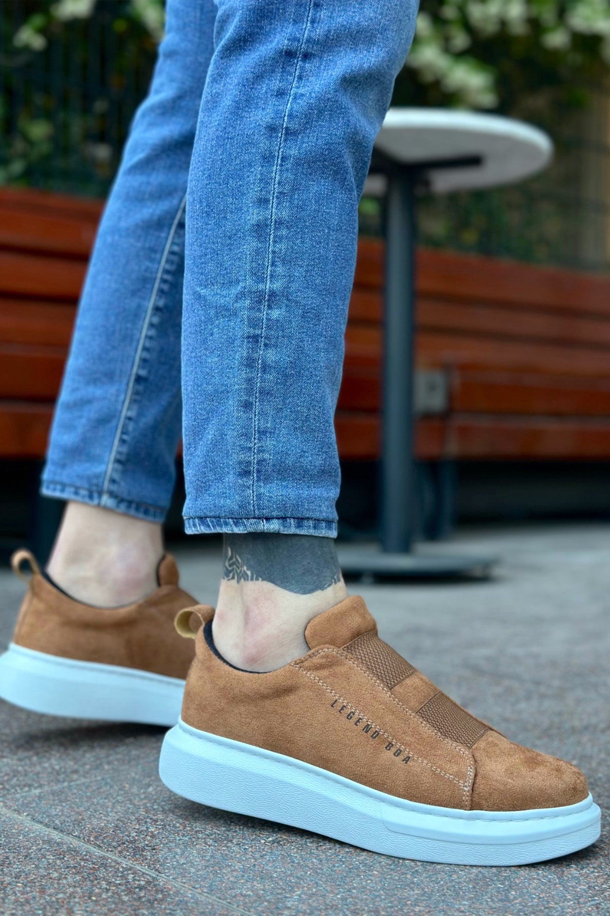 Men's tan suede slip-on sneakers with light blue rubber sole, rear side
