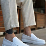Men's casual white loafers, back angle view with smooth upper and low sole