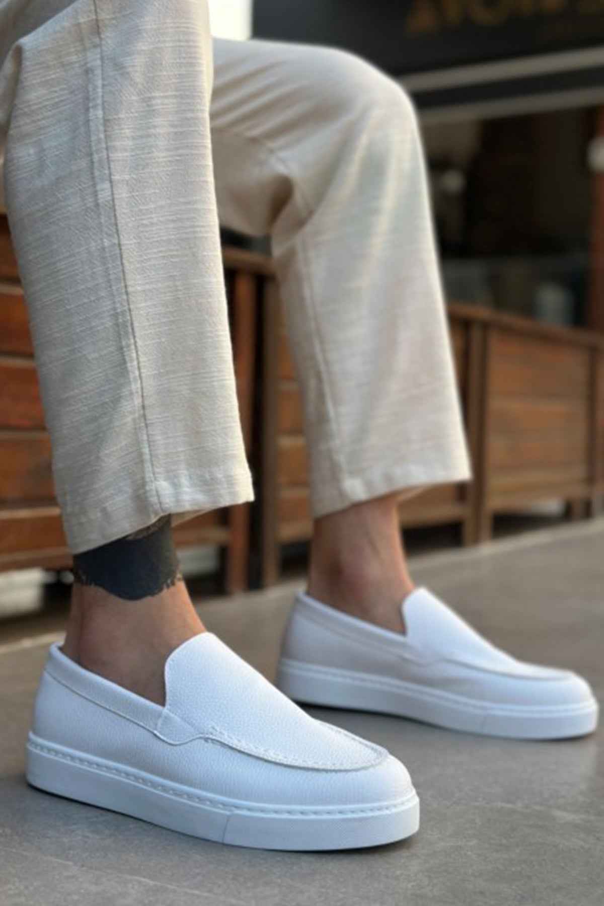 Men's casual white loafers, back angle view with smooth upper and low sole