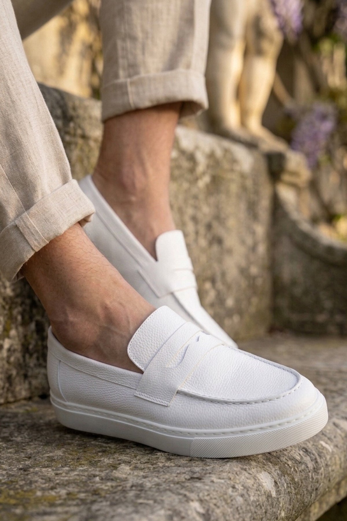 White men's loafers with slip-on strap, stitched apron, and low cushioned sole