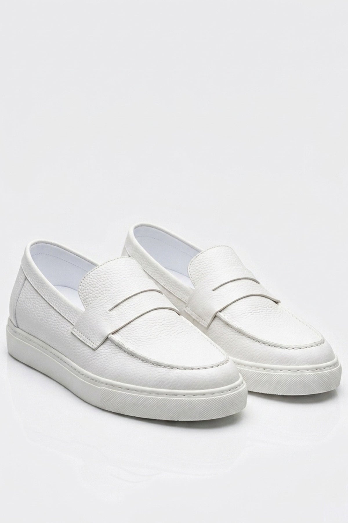 Studio view of white men's loafers with slip-on strap and stitched apron front