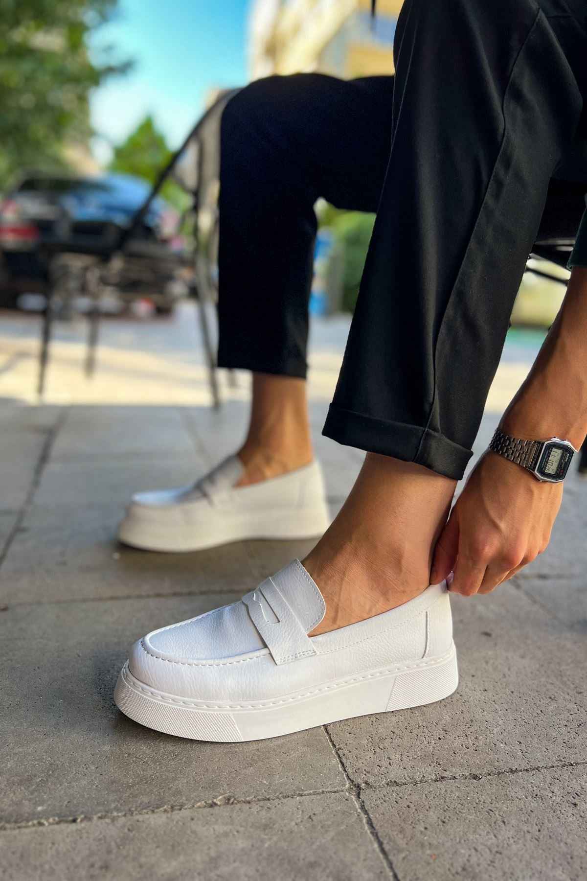 Men's white slip-on loafer, side view with stitched upper and strap tab