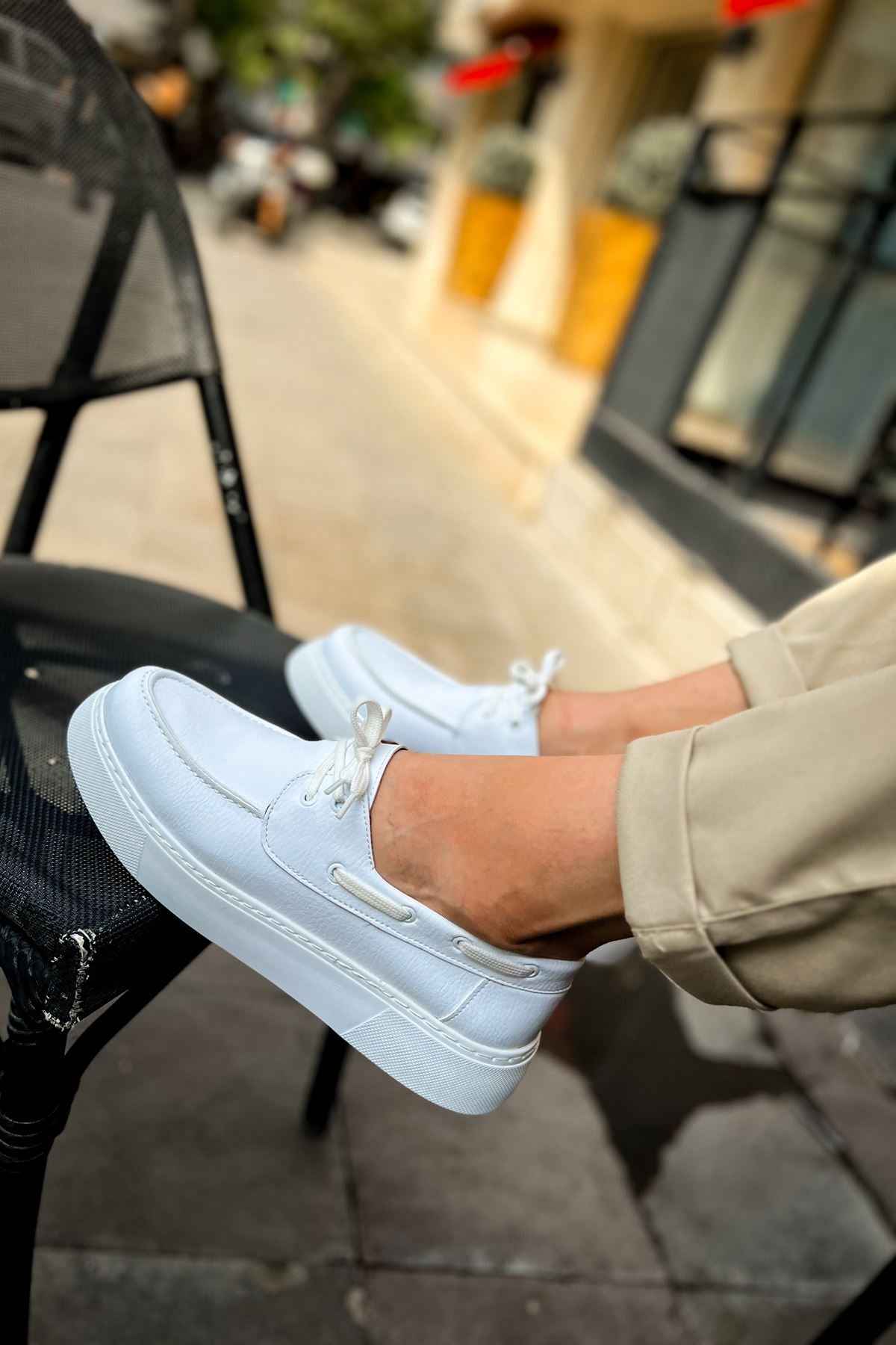 Men's casual white low-top sneakers, side view with lace and stitching