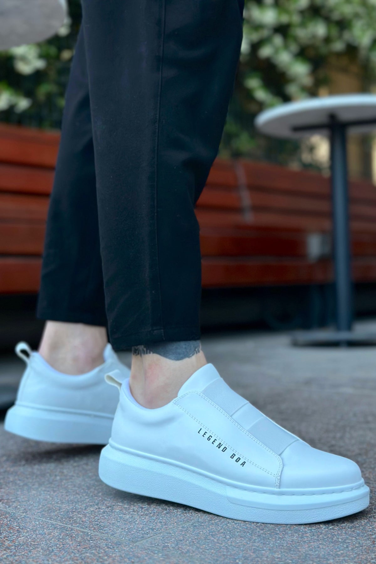 Men's low-top white slip-on sneakers, side view, thick rubber sole